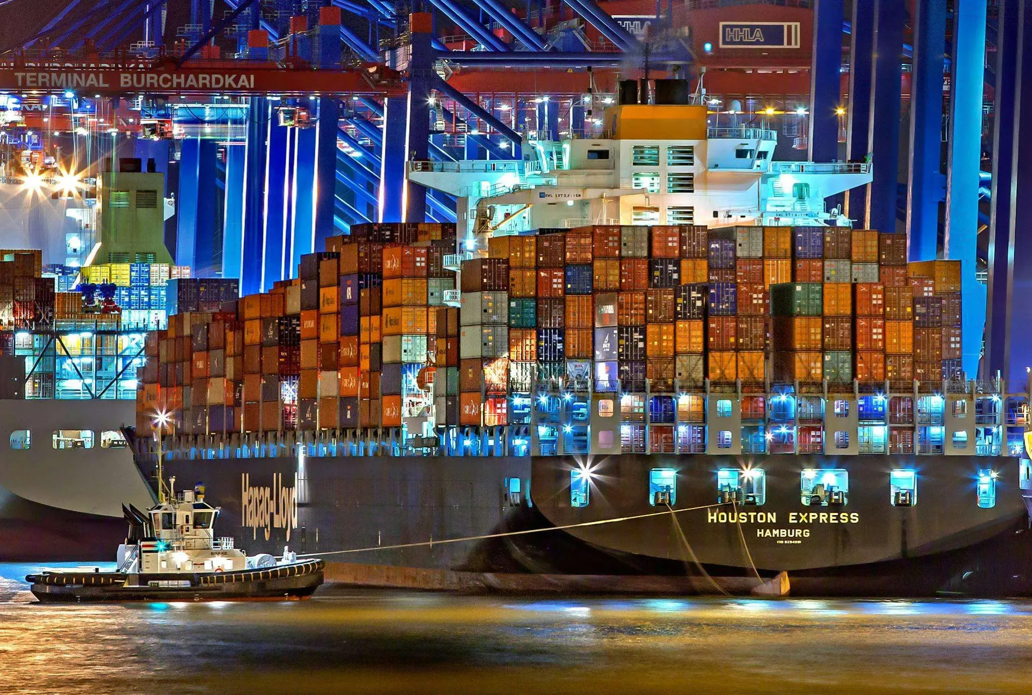 Container ship at an illuminated international cargo terminal