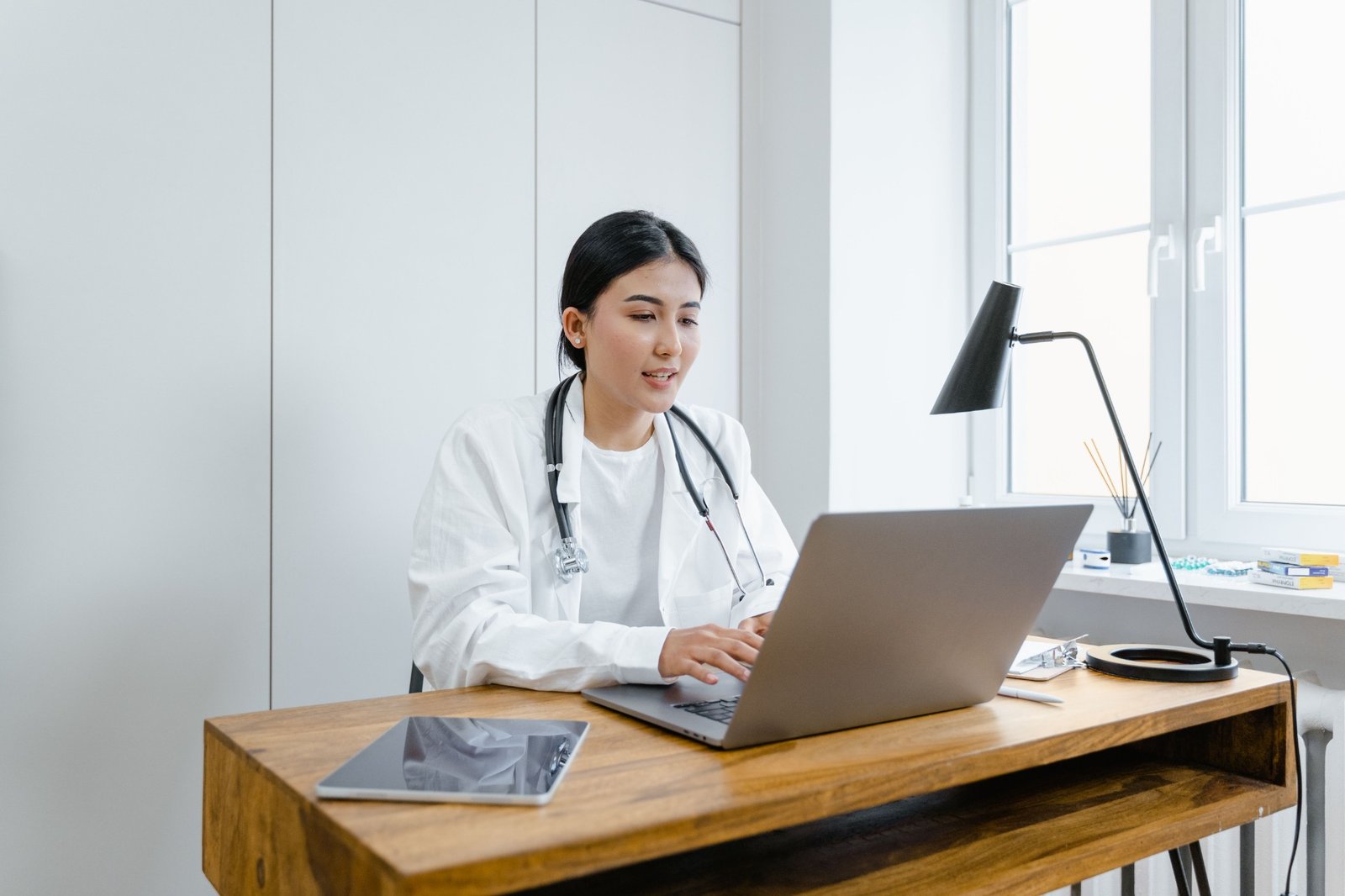 Clinician using a laptop, illustrative online-care photography