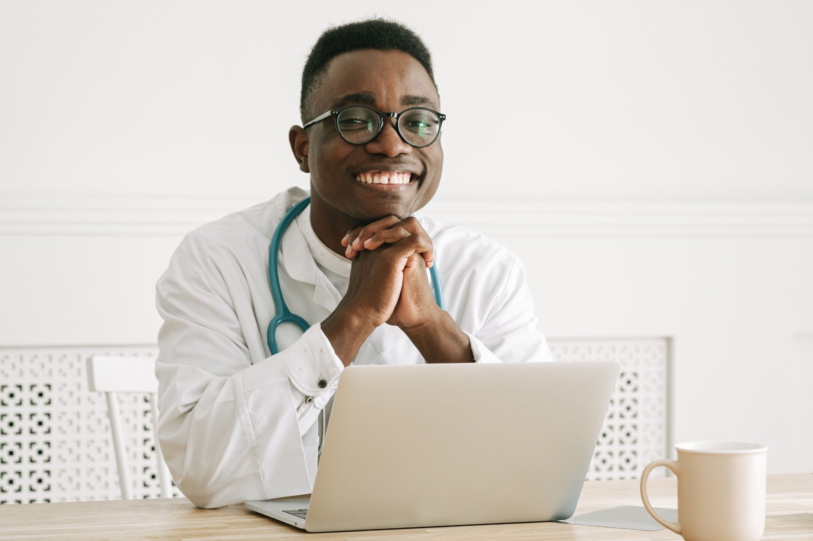 Clinician seated at a laptop, illustrative online-care photography